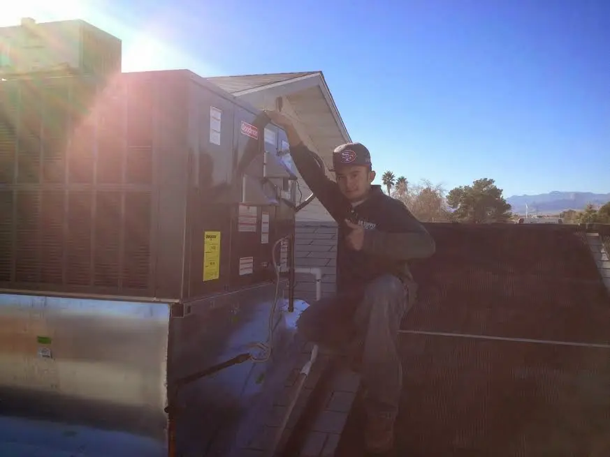 HVAC technician performing Boiler Repair on a rooftop unit in Hampstead